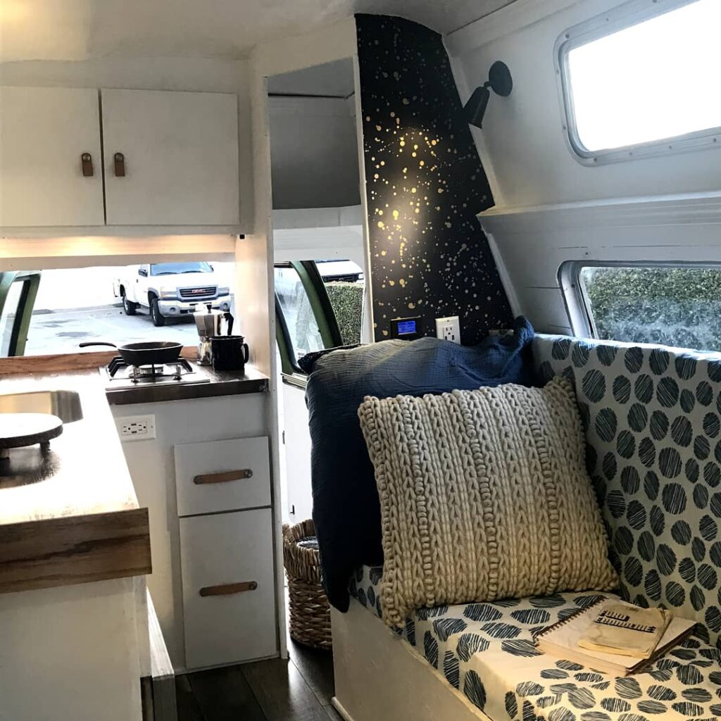 A beautifully designed, cozy camper van interior showcasing the comfort and peace of mind achieved through Vanpire Customs' professional maintenance and off-grid builds in Los Angeles, California.