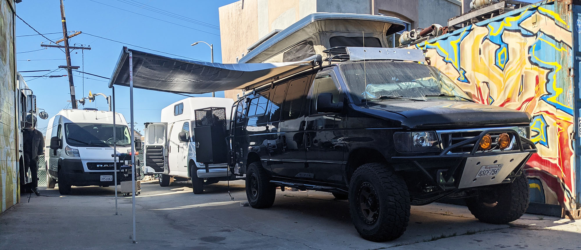 Vanpire Customs mobile RV and camper van repair service working on multiple rigs in Los Angeles, California, showcasing our capability to handle diverse vehicle platforms.