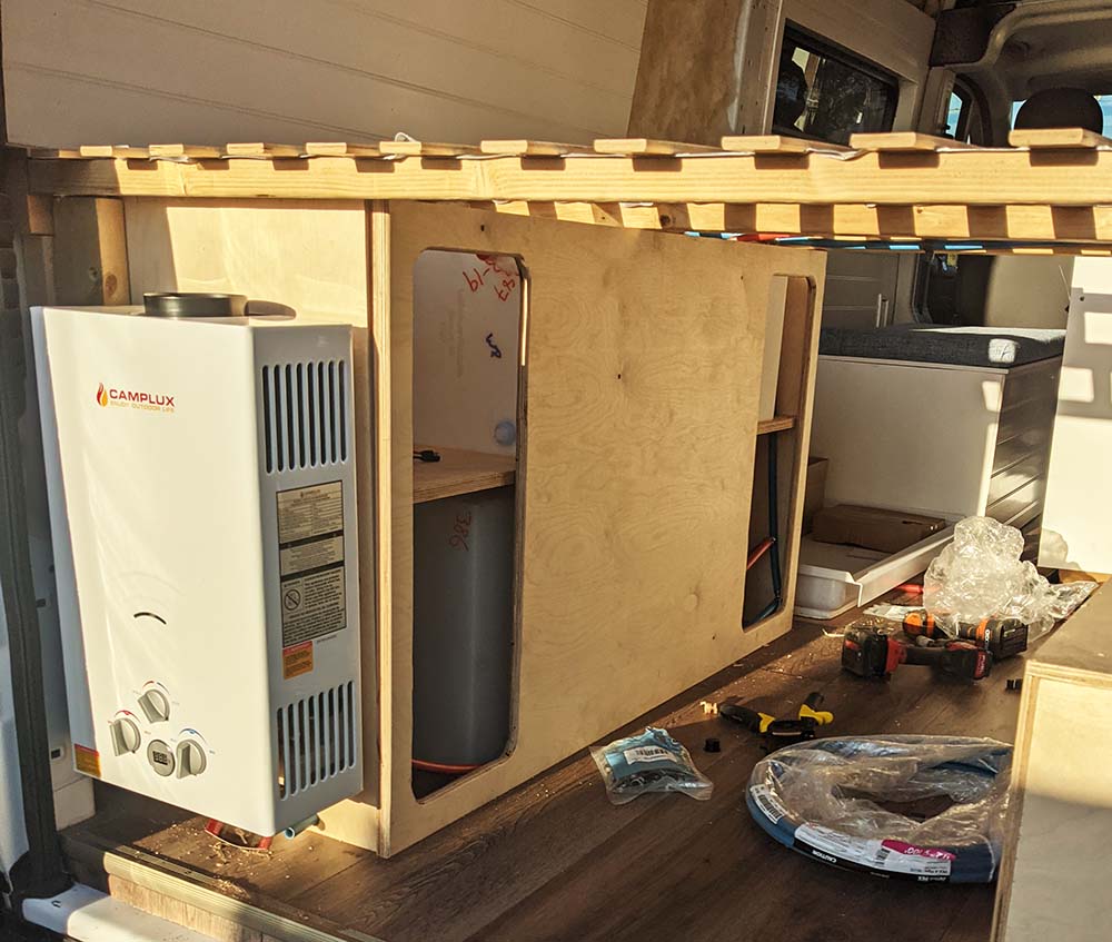 Professional installation of a Camplux water heater system in a camper van by Vanpire Vans, showcasing our mobile repair and technical upgrade services.