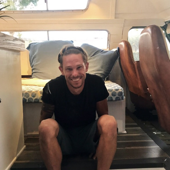 Dustin, founder of Vanpire Vans in Los Angeles, sitting inside a custom camper van. A passionate expert dedicated to crafting mobile living solutions for adventurers.